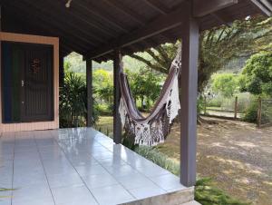een veranda met een hangmat in een huis bij Sítio Herman Natureza Viva in Rolante +56 foto's