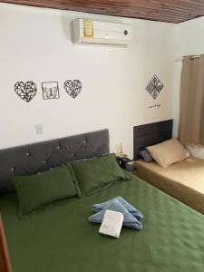 sypialnia z 2 łóżkami i zieloną narzutą w obiekcie Casa aconchegante e privativa w Foz do Iguaçu