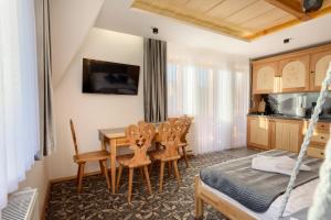 Una sala de estar con mesa de comedor y sillas. en Modrzewiowa Apartamenty, en Poronin