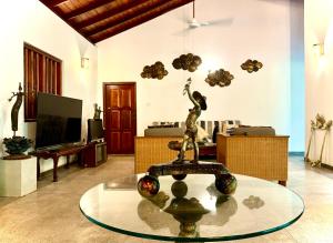 Una sala de estar con una estatua de una mujer en una fuente. en Lotus and Moon, en Habaraduwa Central