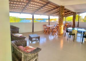 a living room with a table and chairs and a view of the ocean at pousada Requenguela in Icapuí