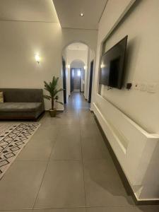 a living room with a couch and a television on a wall at Najd Hotel in AlUla