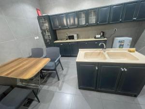 a kitchen with a sink and a table with chairs at Najd APARTMENTS in Al-ʿUla