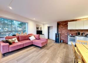 un salon avec un canapé rose et une cuisine dans l'établissement Widokówka Zacisze, à Brodnica Dolna 30 autres photos