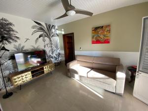 a living room with a couch and a flat screen tv at Maison de vacance 2 Chambres à 200m de la plage in Sainte-Anne