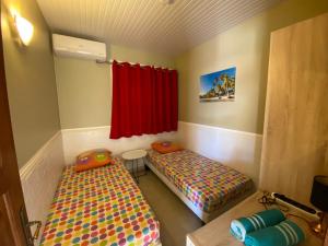 a room with two beds and a red curtain at Maison de vacance 2 Chambres à 200m de la plage in Sainte-Anne +21 photos
