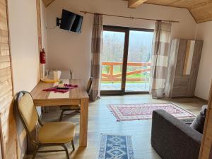 a living room with a wooden table and a couch at Cabana Izvorul Rece Maramureş in Baia-Sprie