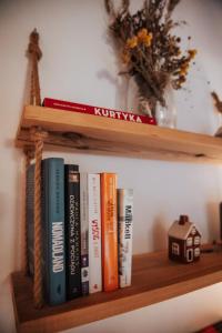 ein Regal mit Büchern und einem Spielzeughaus darauf in der Unterkunft Dream house surrounded by silence in Milicz