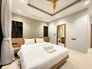 a bedroom with a large white bed and a ceiling at Chalong Brand New 4BR Pool Villa Phuket VVPHU51 in Chalong 