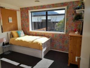 a bedroom with a bed in a brick wall at Beautiful Home in Lake Hawea in Lake Hawea +12 photos