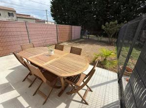 La maison Titi Maison cosy & chaleureuse في Peujard: طاولة وكراسي خشبية على الفناء