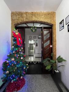 Un árbol de Navidad en el pasillo de un edificio en Hostel Anprado #10, en Guarulhos