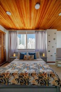 a bedroom with a large bed with a wooden ceiling at Habitación doble baño privado cerca al mar y bahia in Cartagena de Indias