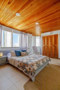 a bedroom with a large bed with a wooden ceiling at Habitación doble baño privado cerca al mar y bahia in Cartagena de Indias