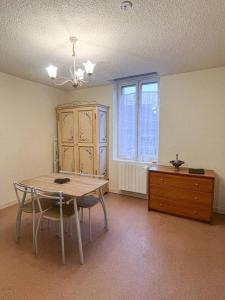 ein Esszimmer mit Tisch, Stühlen und einer Kommode in der Unterkunft le primo - Château - Ville in Château-Chinon