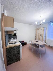 eine Küche mit einem Tisch und einem Tisch sowie ein Esszimmer in der Unterkunft le primo - Château - Ville in Château-Chinon