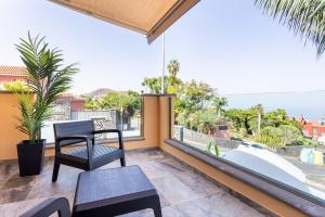 Una sala de estar con una silla y una ventana grande. en Zafiro Piscina Climatizada Jacuzzi Barbacoa Vistas al mar, en La Orotava
