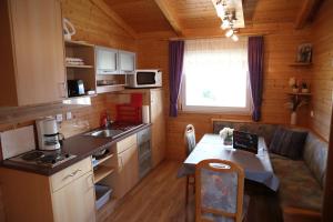 a kitchen with a small table in a cabin at Ferienhaus LiRa in Drobollach am Faaker See