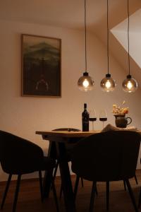 a dining room with a table with two glasses of wine at Panorama Domblick in St. Blasien