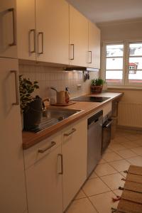 a kitchen with white cabinets and a sink at Panorama Domblick in St. Blasien