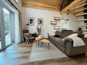 a living room with a couch and a table at Whispering Woods Cabin in Milicz