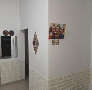 a white wall with some pictures on it at Passadeira Garden in São Tomé