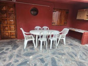 einen weißen Tisch und Stühle in einem Zimmer mit einer roten Wand in der Unterkunft Casa Sta RoCa in Santa Clara del Mar