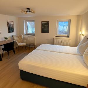 Una habitación de hotel con una cama grande y una mesa. en Maisonett am Rebhügel-modern wohnen in den Weinbergen, en Bühl