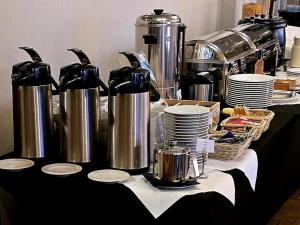 ein Tisch mit silbernen Kesseln und Tellern darauf in der Unterkunft Six Suites, Old Town in Danzig