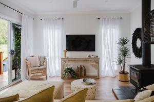 sala de estar con cortinas blancas y chimenea en The Lake Escape, en Yatte Yattah