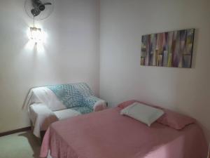 a bedroom with a bed and a chair and a fan at Fernando e Fernanda in Itupeva