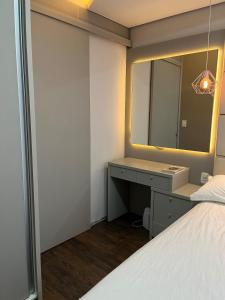 a bedroom with a bed and a vanity with a mirror at Centro de união da vitória in União da Vitória