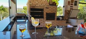 two glasses of wine sitting on a table in front of a fireplace at Fernando e Fernanda in Itupeva