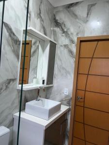 a bathroom with a white sink and a mirror at Centro de união da vitória in União da Vitória