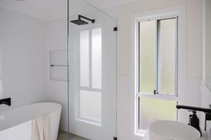 Un baño blanco con bañera y ventana. en The Lake Escape, en Yatte Yattah 32 fotos más