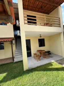 a patio with a table and chairs on a house at Chalés Boqueirão beach in Japaratinga
