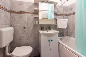 a bathroom with a sink and a toilet and a tub at House Nevenka in Medulin +28 photos
