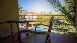 einen Tisch und einen Stuhl auf einem Balkon mit Pool in der Unterkunft Ocean Dream top floor apt with balcony in Cabarete