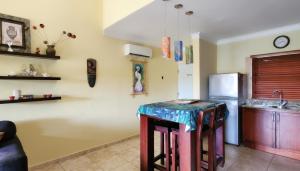 eine Küche mit Tisch und Kühlschrank in der Unterkunft Ocean Dream top floor apt with balcony in Cabarete + 18 Fotos