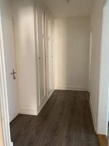 an empty room with white walls and wooden floors at Zentrale Unterkunft in Bern
