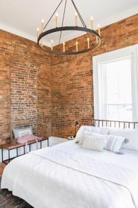 a bedroom with a brick wall and a large bed at East Main Your Merry Modern Downtown Getaway in Bowling Green