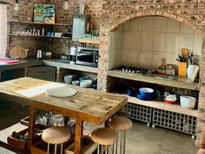 a kitchen with a wooden table and stools at De Krantz 6 Estate in Clarens +22 photos