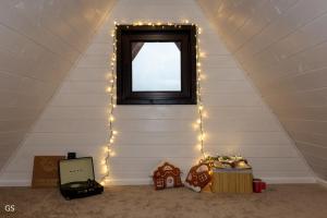 a room with a window with lights and a table at Casa Sunetul Padurii din Belis Apuseni in Finciu