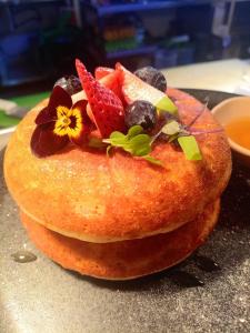 ein Kuchen mit Früchten und Blumen darauf in der Unterkunft Hotel Ryo 74B in Medellín