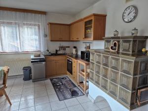 kuchnia z drewnianymi szafkami i zegarem na ścianie w obiekcie Apartment Ad Alta - Flattach w mieście Flattach +11 zdjęć