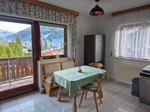 a kitchen with a table and a balcony with a view at Chalet Ad Alta - Flattach in Flattach