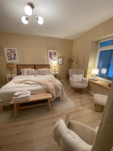 a bedroom with a large bed and a chair at Bonne Vie Cottage - Zebegény in Zebegény