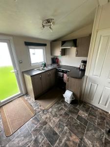 a small kitchen with a sink and a window at 16 orchid meadows in Ashington
