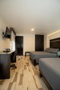 una camera d'albergo con due letti e una scrivania di Hotel San José Plaza Coatepec a Coatepec