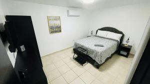 a bedroom with a bed and a picture on the wall at Red House - Modern 2BR Near isla verde & Airport in Carolina